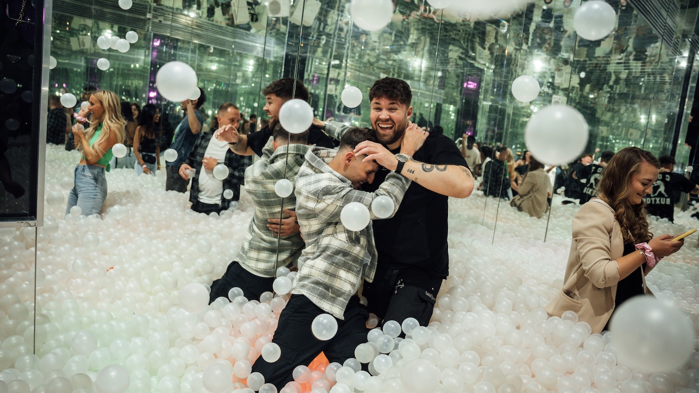 two men in a ball pit wrestling each other