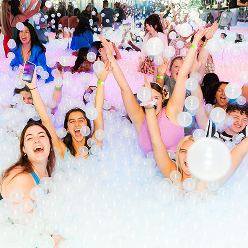 a group of girls throwing balls in a ball pit